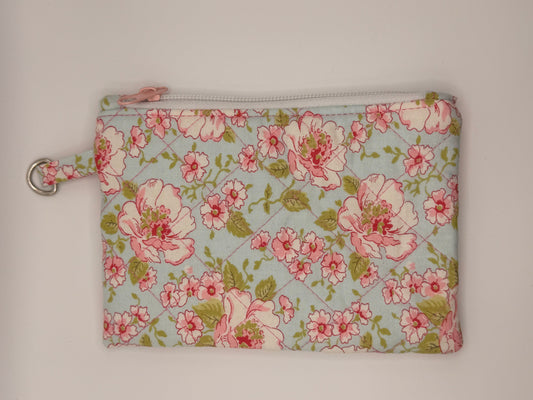 Floral-patterned pouch with pink flowers on a light blue background