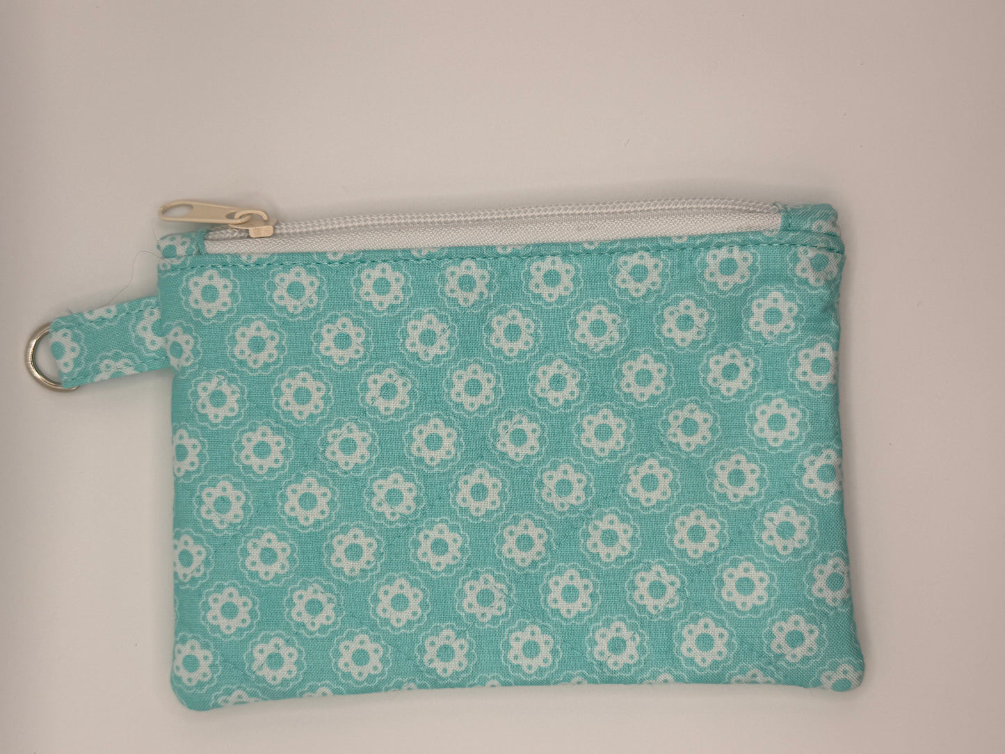 Small blue pouch with white floral pattern on a light blue background